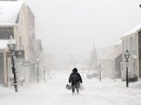 A woman walks down Centre Street in New Bedford, MA as a snow storm sweeps across the area.   PETER PEREIRA/THE STANDARD-TIMES/SCMG